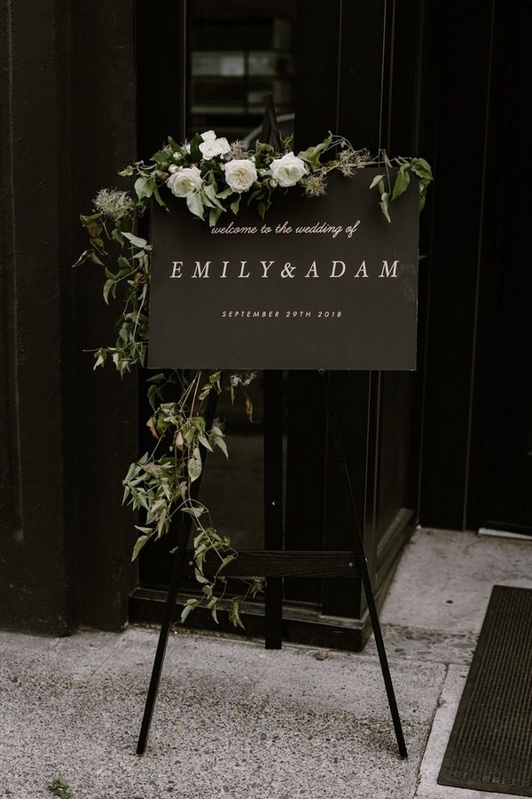 Black wedding welcome signage with greenery folige